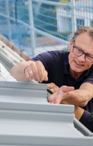 Zambelli Monteure auf dem Dach eines Wohnhauses, auf dem das Zambelli RIB-ROOF Akustikdach verlegt wird